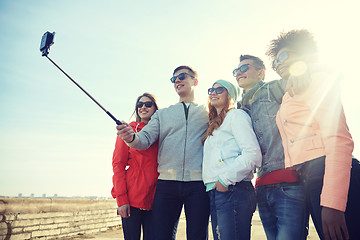 Image showing smiling friends taking selfie with smartphone