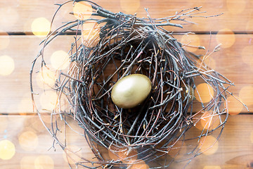 Image showing close up of golden easter egg in nest on wood