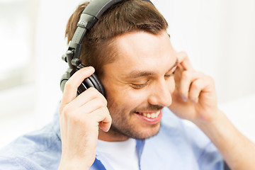 Image showing smiling young man in headphones at home