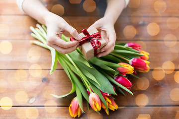 Image showing close up of woman with gift box and tulip flowers