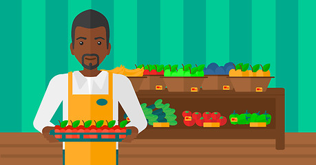 Image showing Supermarket worker with box full of apples.