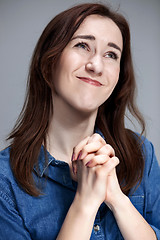 Image showing Woman is looking imploring over gray background