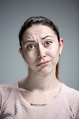 Image showing Woman is looking imploring over gray background