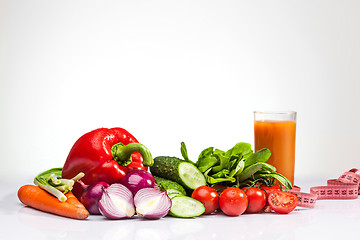 Image showing The tape measure with tomatoes and vegetables on white