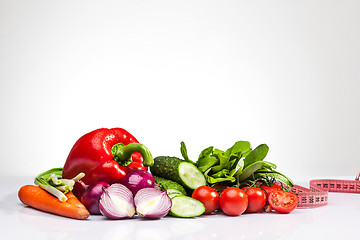 Image showing The tape measure with tomatoes and vegetables on white