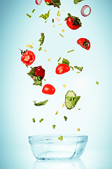 Image showing The vegetables for salad falling on blue