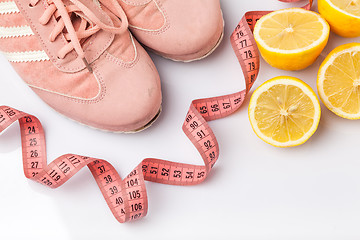 Image showing The old sneakers, a meter tape and lemon on an white