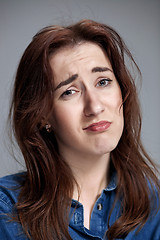 Image showing Woman is looking imploring over gray background