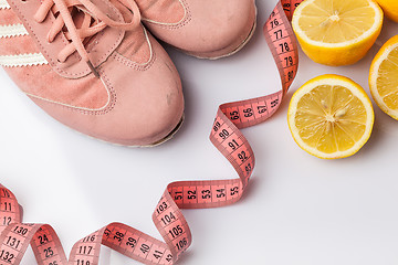 Image showing The old sneakers, a meter tape and lemon on an white