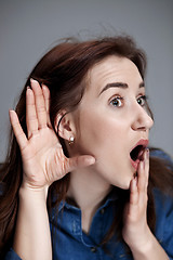 Image showing Young woman trying to listen something