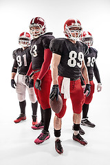 Image showing The four american football players posing with ball on white background