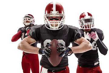 Image showing The three american football players posing with ball on white background