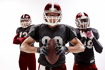 Image showing The three american football players posing with ball on white background