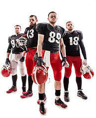 Image showing The four american football players posing with ball on white background