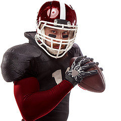 Image showing American football player posing with ball on white background