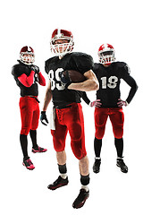 Image showing The three american football players posing with ball on white background
