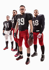 Image showing The four american football players posing with ball on white background