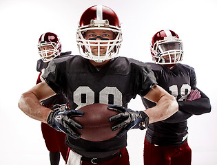 Image showing The three american football players posing with ball on white background