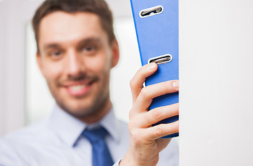 Image showing close up of businessman with ring binder in office