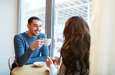 Image showing happy couple drinking tea and coffee at cafe