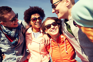 Image showing smiling friends in sunglasses laughing on street