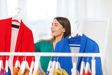 Image showing happy woman choosing clothes at home wardrobe