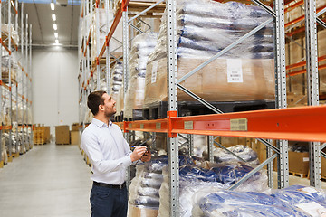 Image showing businessman with clipboard at warehouse