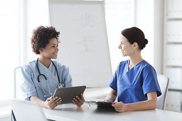 Image showing happy doctors with tablet pc meeting at hospital