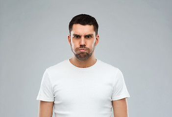 Image showing man with funny angry face over gray background