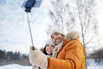 Image showing happy couple taking selfie by smartphone in winter