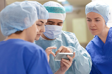 Image showing group of surgeons with smartphone at hospital