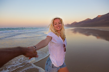 Image showing Romantic couple, holding hands, having fun on beach.