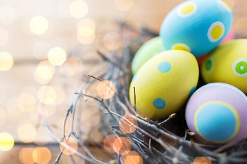 Image showing close up of colored easter eggs in nest on wood