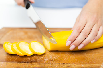 Image showing close up of hands chopping squash with knife