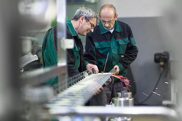 Image showing Industrial worker grinding in manufacturing plant.