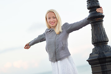 Image showing Lady relaxing on fresh breeze by sea in spring.