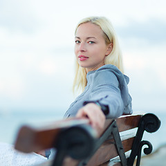 Image showing Lady sitting on a bench outdoors