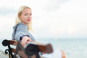 Image showing Lady sitting on a bench outdoors