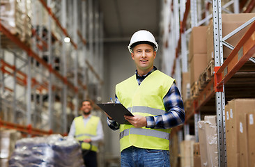 Image showing man with clipboard in safety vest at warehouse