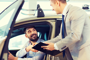 Image showing happy man with car dealer in auto show or salon