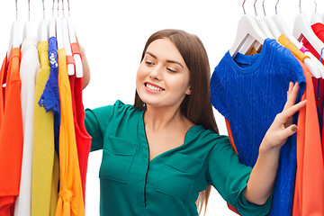 Image showing happy woman choosing clothes at home wardrobe