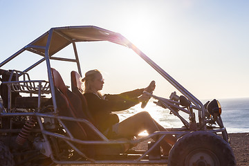 Image showing Woman driving quadbike in sunset.