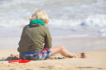 Image showing Boy playing with toys on beach.