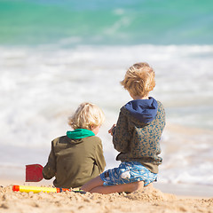 Image showing Boys playing with toys on beach.