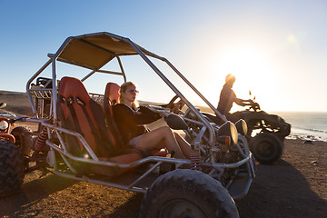 Image showing Woman driving quadbike in sunset.