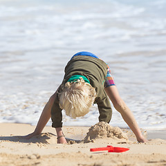 Image showing Boy playing with toys on beach.