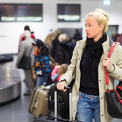 Image showing Female traveler transporting luggage in airport.