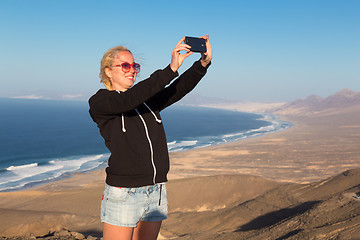 Image showing Woman snaping holiday selfie on El Cofete beach