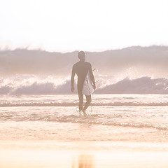 Image showing Silhouette of surfer on beach with surfboard.