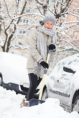 Image showing Independent woman shoveling snow in winter.